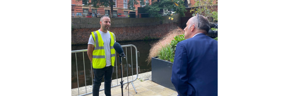 Michael wearing a high vis jacket getting interviewed